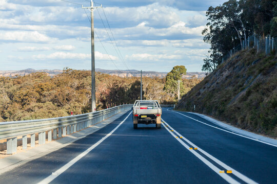 Ute travelling on mountain road with guardrail