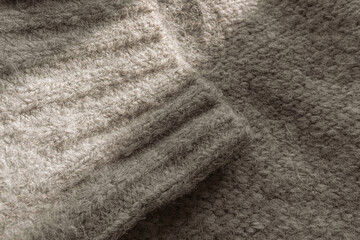 Texture of gray woolen sweater close-up. Knitted sweater. Woolen clothes. Winter warm things. Home comfort. Winter background. Knitting pattern. Vintage photo. Wool texture.