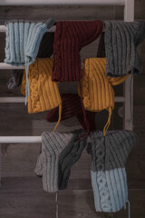 Knitted socks. Woolen clothes. Winter accessories. Christmas stockings. Laundry is drying. Colorful things. Domestic life. Cozy winter background. Colored knitted socks with a pattern. Vintage photo.