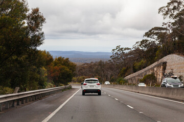 Car travelling down highway road in Blue Mountains on overcast day