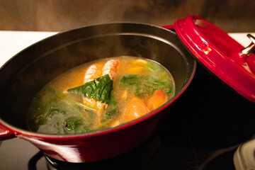 おしゃれな赤いダッチオーブンの鍋に入った調理中の海鮮ブイヤベース・味噌汁・トマトスープ（千葉県）