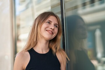 Young blonde woman smiling confident looking to the side at street