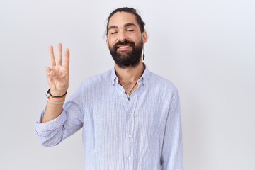 Fototapeta premium Hispanic man with beard wearing casual shirt showing and pointing up with fingers number three while smiling confident and happy.