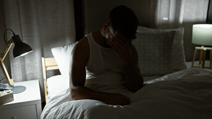 Fototapeta premium Young arab man stressed sitting on bed at bedroom