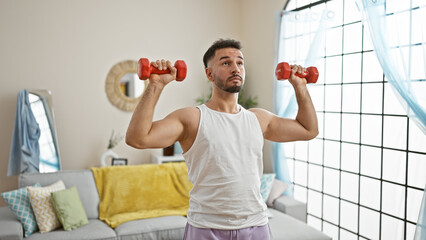 Young arab man using dumbbells training at home