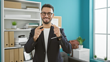 Young arab man business worker pointing to camera smiling at the office