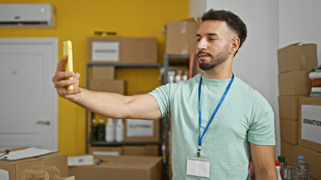 Young arab man volunteer make selfie by smartphone smiling at charity center