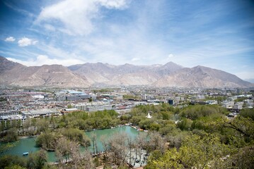 Idyllic valley surrounded by towering mountains with a view of Lhasa city