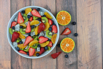 Fresh fruit salad bowl on wood grain table concept healthy food, to control weight, to lose weight