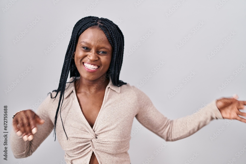 Sticker african woman with braids standing over white background dancing happy and cheerful, smiling moving 