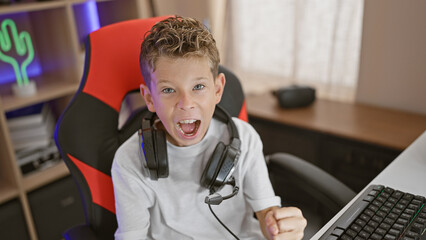 Adorable blond boy streaming victorious celebration, gaming enthusiast wins, smiling in a dark...