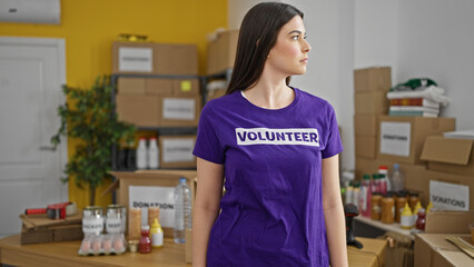 Young beautiful hispanic woman volunteer standing with serious face at charity center