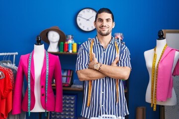 Young hispanic man tailor smiling confident standing with arms crossed gesture at sewing studio