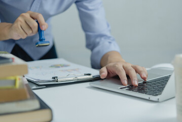 Man stamping approval of work finance banking or investment marketing documents on desk..