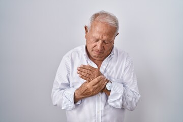 Senior man with grey hair standing over isolated background suffering pain on hands and fingers, arthritis inflammation