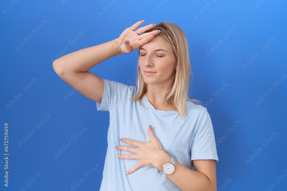 Canvas Prints Young caucasian woman wearing casual blue t shirt touching forehead for illness and fever, flu and cold, virus sick