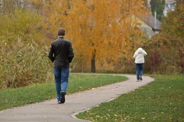 A man follows a woman who moves away from him along a path among autumn nature. Difficulties in the relationship between the sexes. Romantic relationships and saving family life. Lovers``` psychology