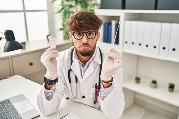 Arab doctor man with beard holding covid test depressed and worry for distress, crying angry and...