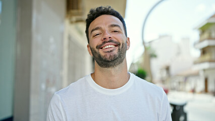 Obraz premium Young hispanic man smiling confident standing at street