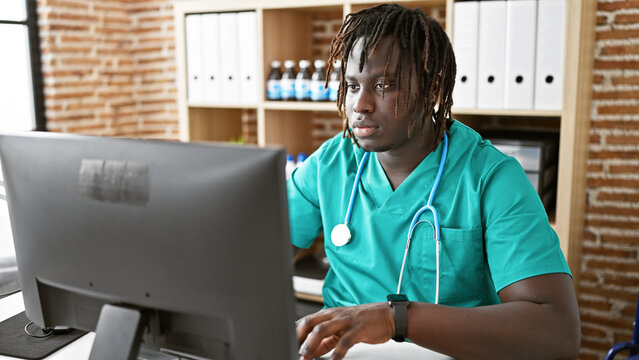 African American Man Doctor Using Computer Working At The Clinic