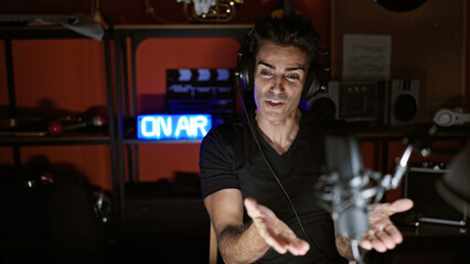 Young hispanic man speaking in a radio show at radio studio