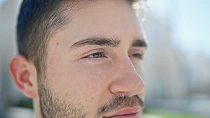 Obraz premium Young hispanic man looking to the side with serious expression at street