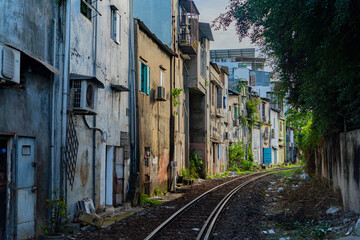 Street - railway.  A small street in Nha Trang in Vietnam with railway tracks running through the residential sector. - obrazy, fototapety, plakaty