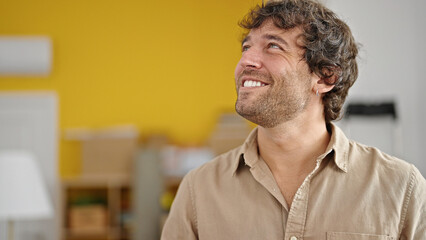 Fototapeta premium Young hispanic man smiling confident looking to the side at new home
