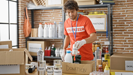 Young hispanic man volunteer packing food cardboard box to donate at charity center