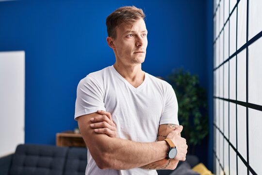 Young man standing with arms crossed gesture at home