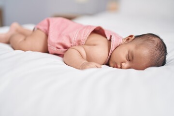Adorable infant lying on bed sleeping at bedroom