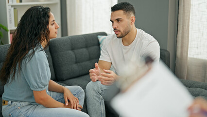 Man and woman sitting on sofa having couple therapy at psychology clinic