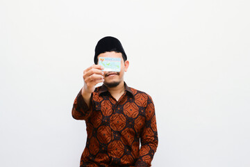 young adult man shows and holds Indonesian identity cards (KTP)