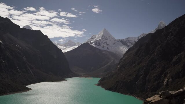 ice covered glacier of a pyramid shaped mountain at laguna paron lagoon in the high andes mountains of the cordillera blanca at huascaran, Peru, with snow covered mountain peaks on a bright sunny day.