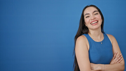 Young beautiful hispanic woman standing with arms crossed gesture saying yes with hand over...