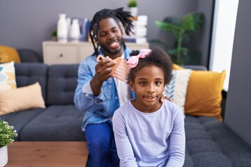 Father and daughter smiling confident combing hair at home