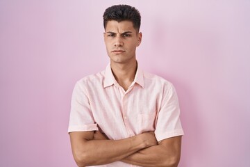 Young hispanic man standing over pink background skeptic and nervous, disapproving expression on...