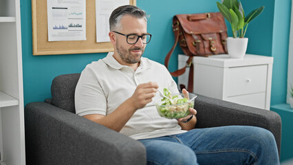 Grey-haired man business worker eating salad at the office