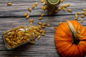 Two jars with pumpkin seeds on a rustic table