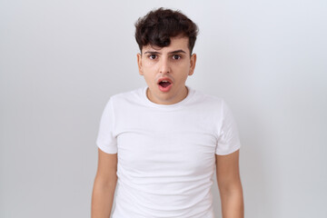 Young non binary man wearing casual white t shirt afraid and shocked with surprise and amazed expression, fear and excited face.