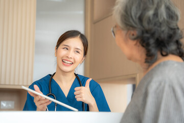 Beautiful asian nurse talking with senior woman patient with smile in hospital. She making...