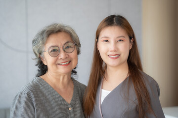 Portrait of beautiful asian woman with senior woman standing in hospital with smiling together.