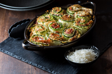 A homemade zucchini roll ups appetizer hot out of the oven with parmesan cheese.