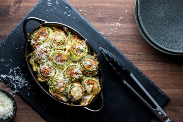 Baked zucchini roll ups hot out of the oven topped with parmesan cheese.