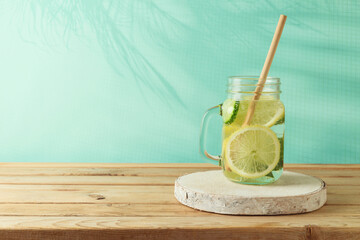 Infused water with lemon and cucumber on wooden table. Detox, diet, healthy eating or  weight loss concept background - obrazy, fototapety, plakaty