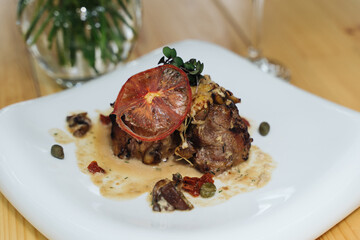Close-up shot of a beautifully plated pork tenderloin with mushroom sauce
