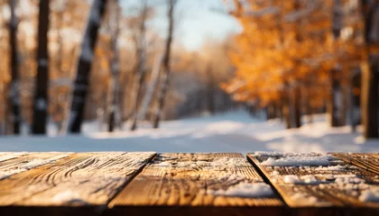 Tuinposter Winter tabletop with fresh snow, blurred forest, and sunny orange fall foliage in 16k super quality © Ilja