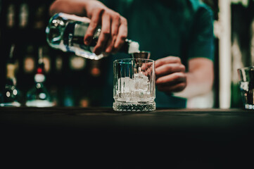 Ice cube in an empty glass on a bar counter in bar or pub