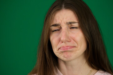 cry different emotions of a young girl on a green background chromakey beautiful facial features...