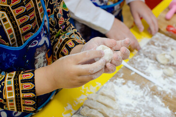 child makes dumplings from dough with minced meat. cooking dumplings at home